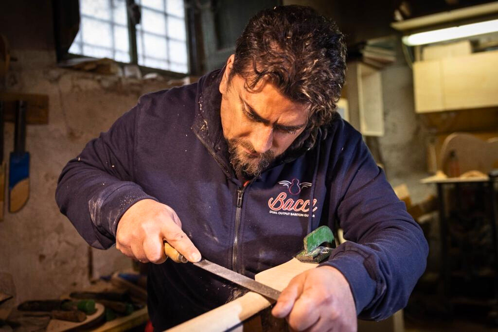 Bruno Bacci luthier at work smoothing wood